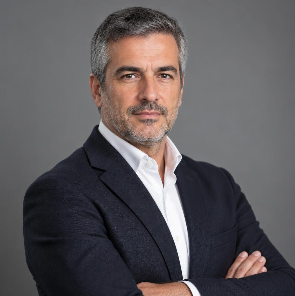 Professional headshot of a Portuguese male journalist in his mid-40s wearing a blazer